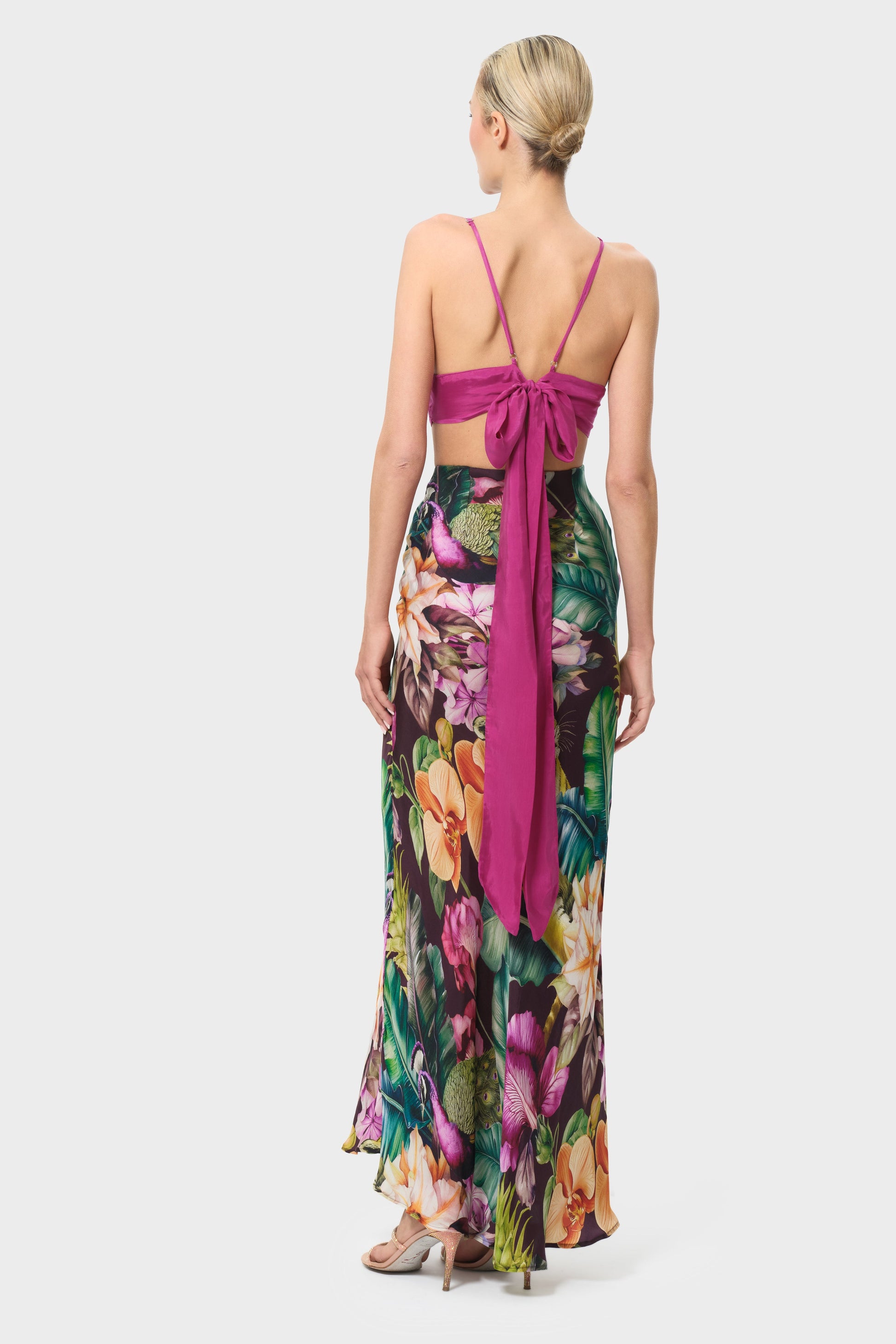 Woman wearing a colorful floral skirt on a white background