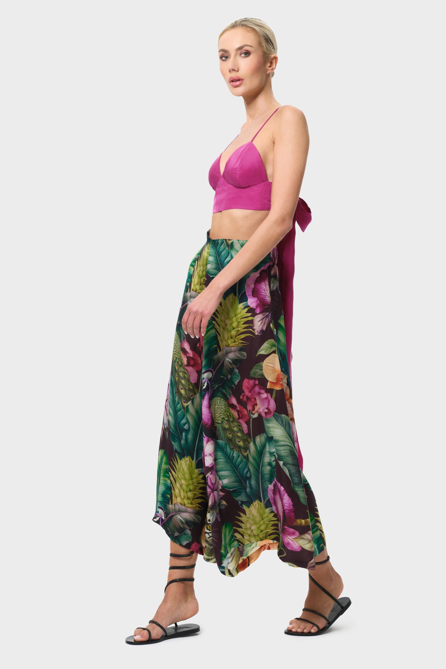 Woman wearing a colorful floral palazzo pants on a white background