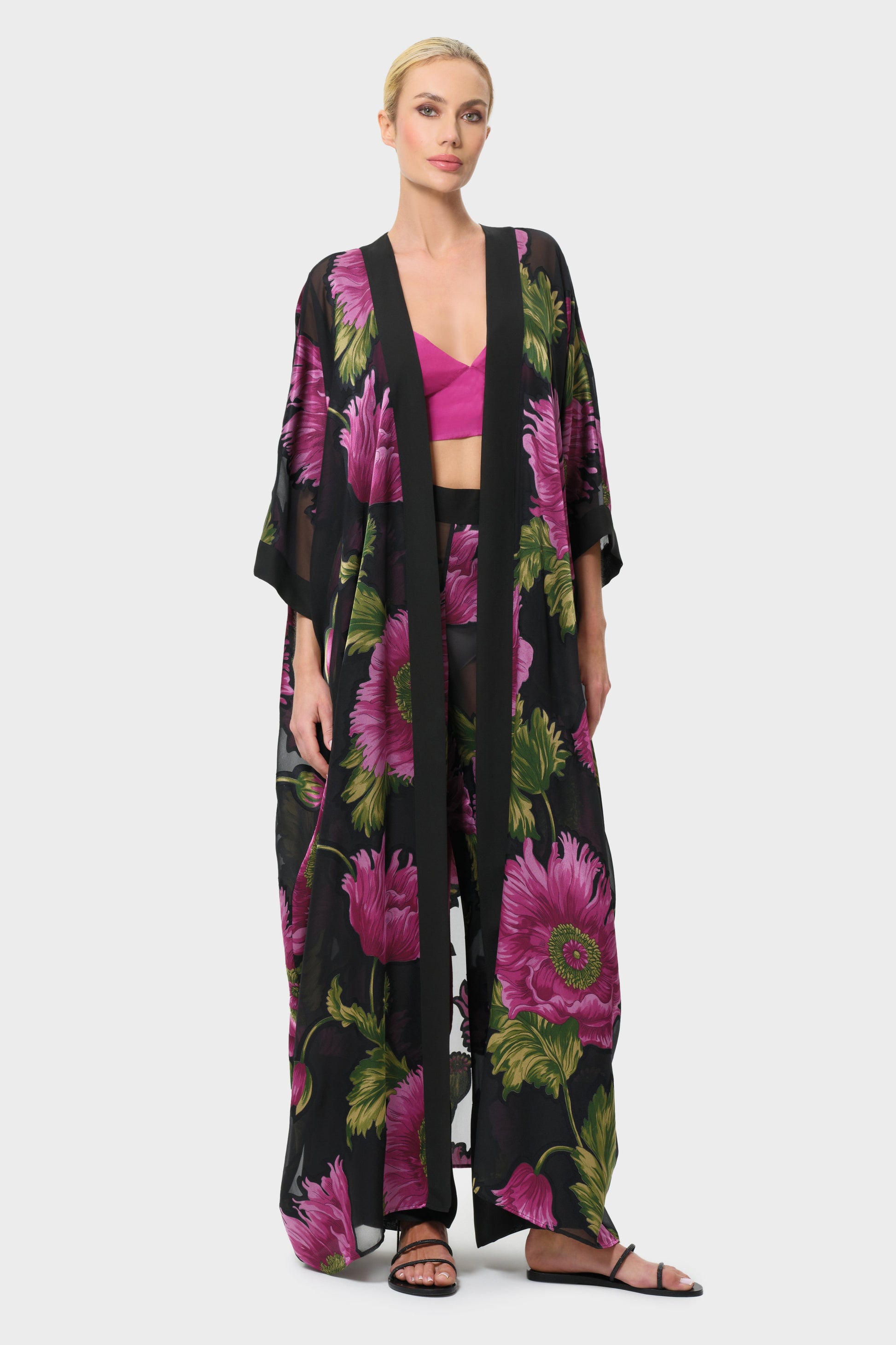 Woman wearing a pink and black floral outfit on a white background