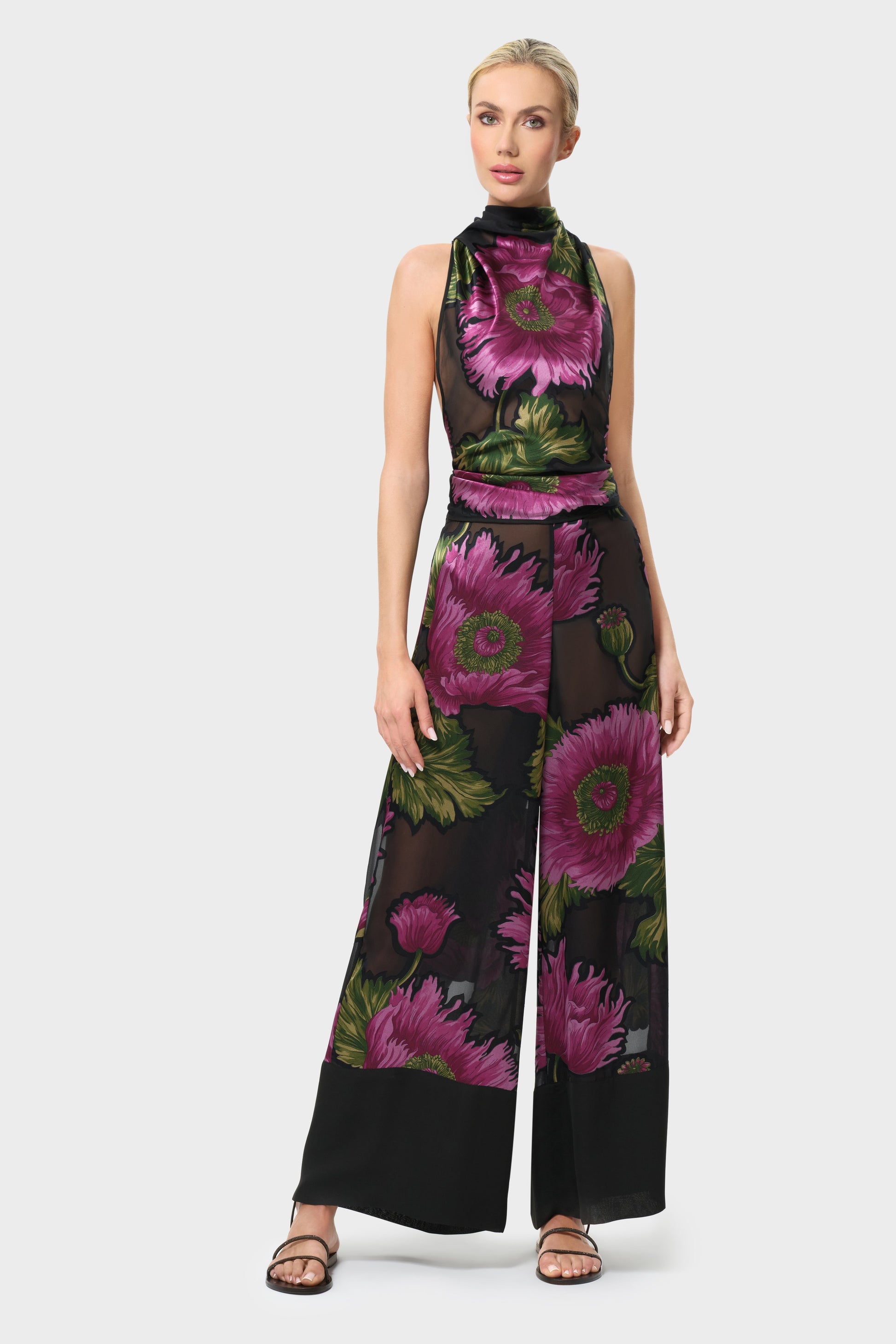 Woman wearing a pink and black floral outfiy on a white background