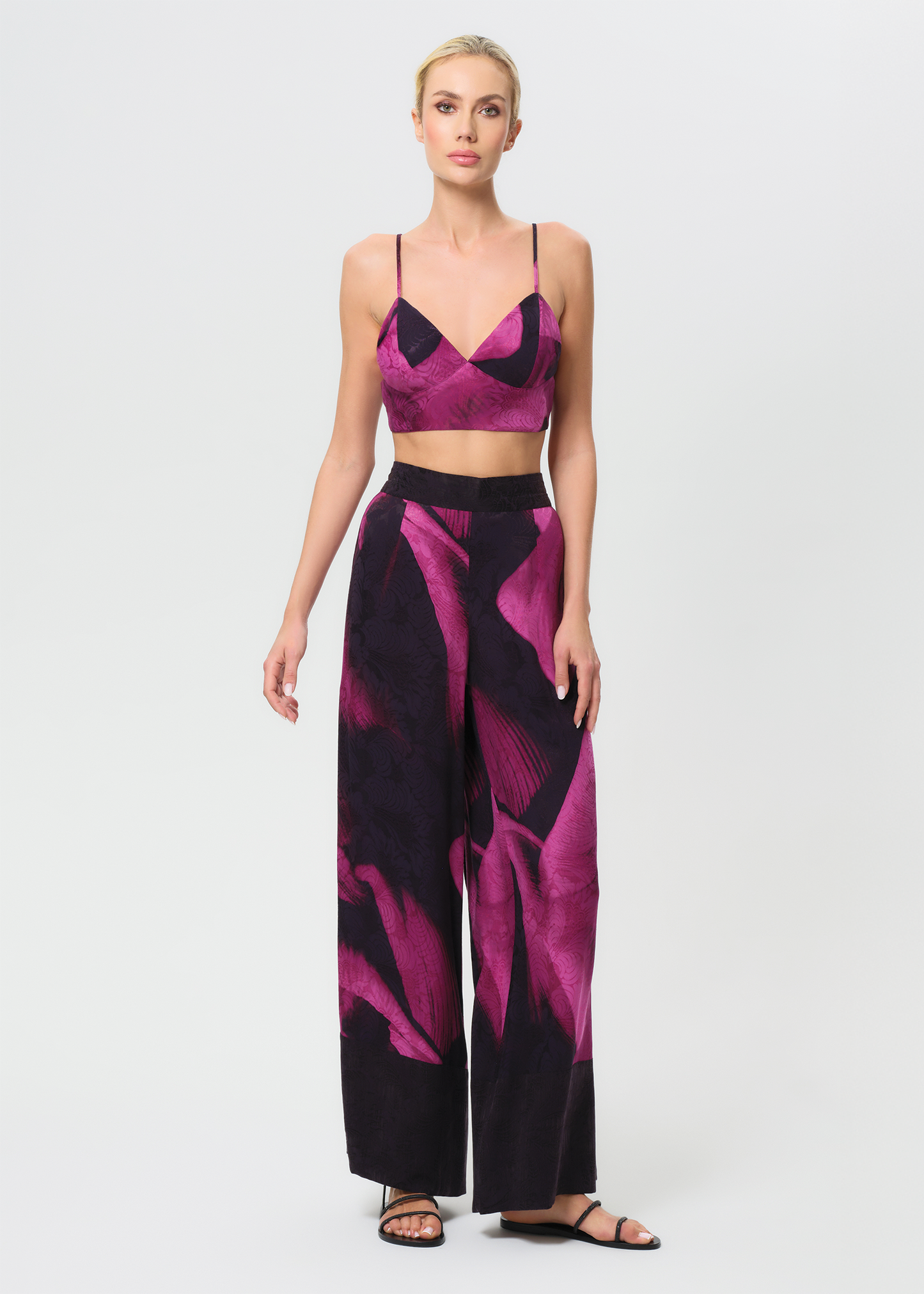 Woman wearing a pink and black patterned outfit on a white background