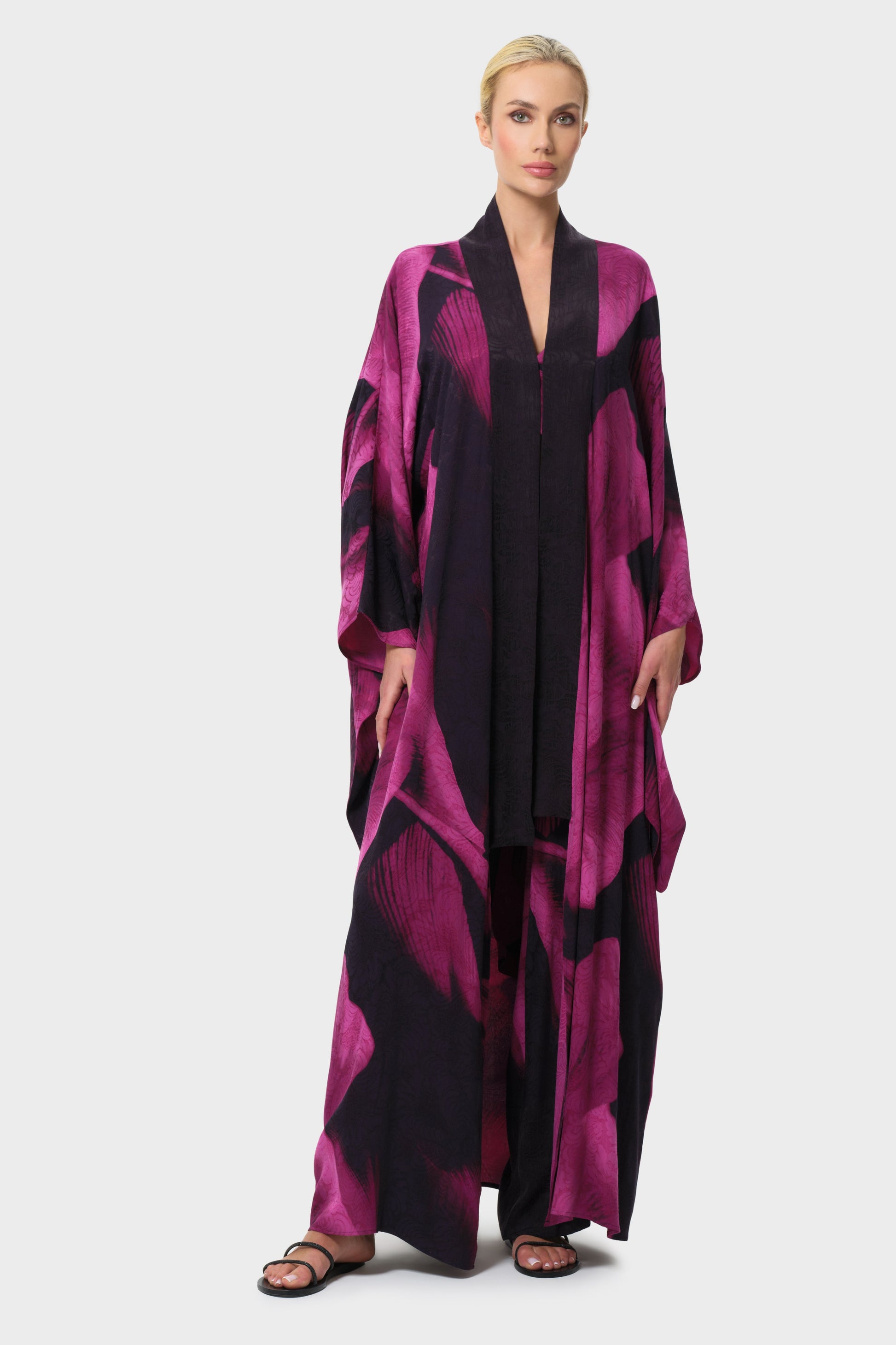 Woman wearing a pink and black patterned robe on a white background