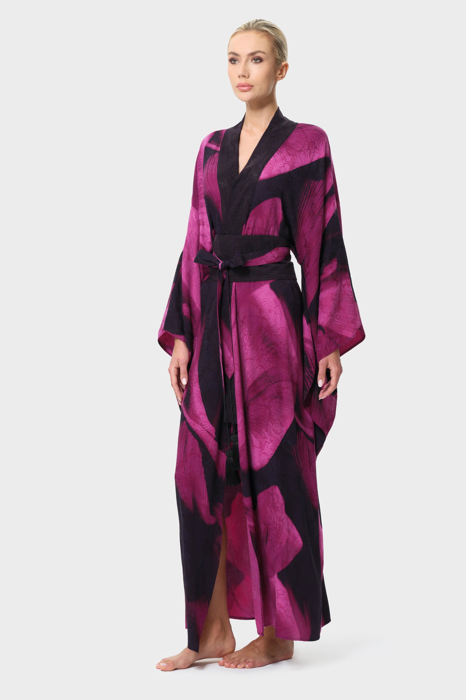 Woman wearing a pink and black patterned robe on a white background