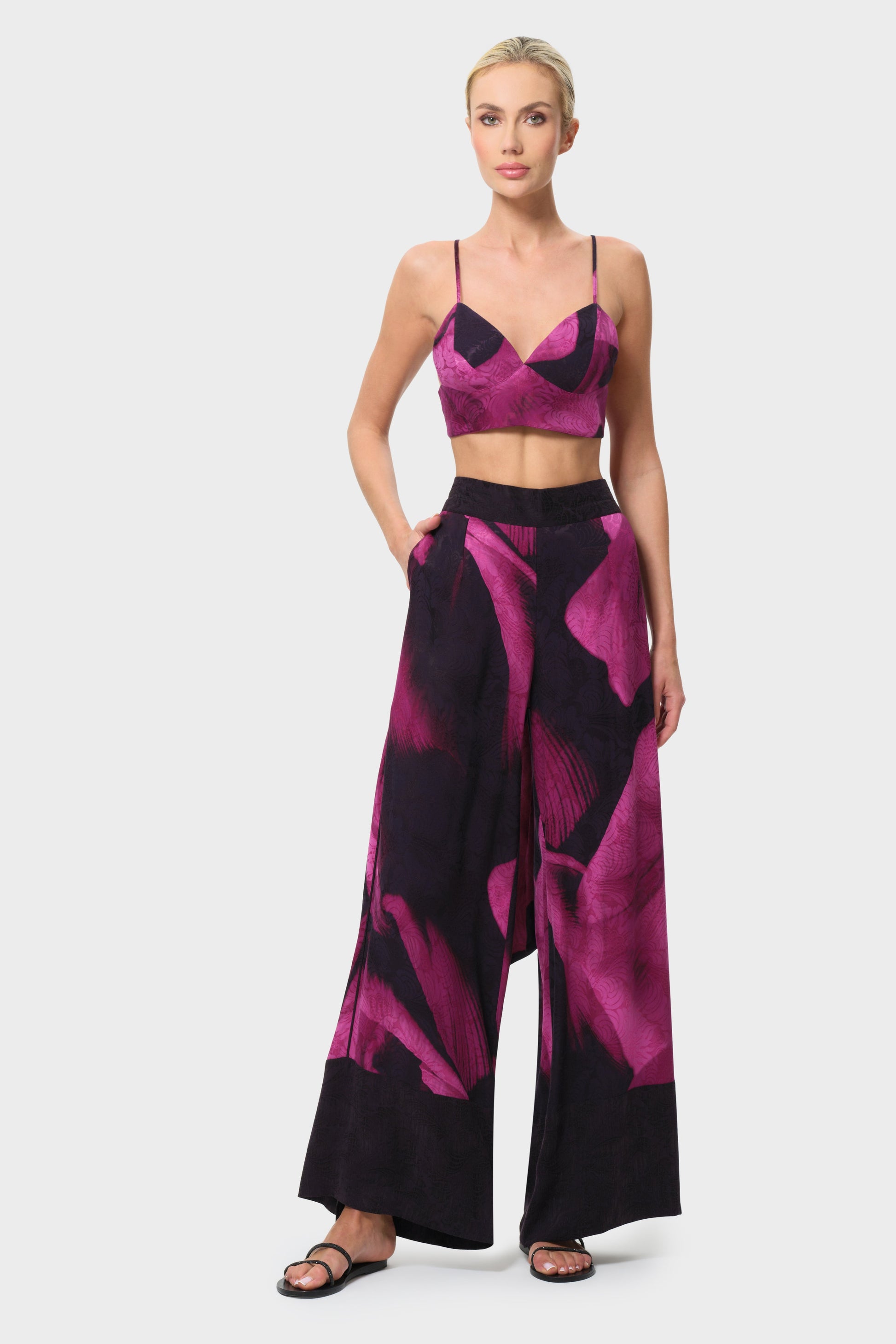 Woman wearing a pink and black patterned outfit on a white background