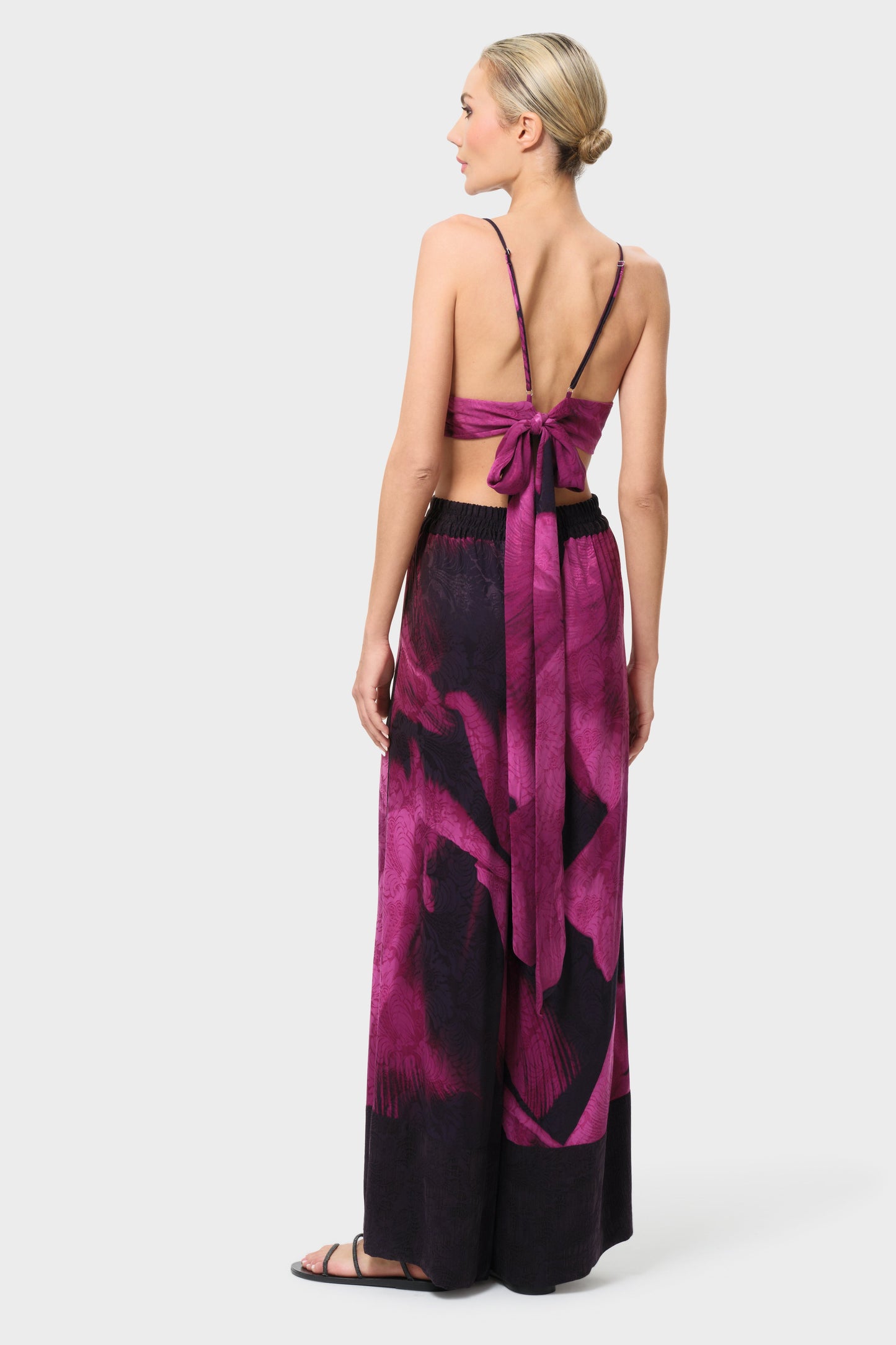 Woman wearing a pink and black patterned outfit on a white background