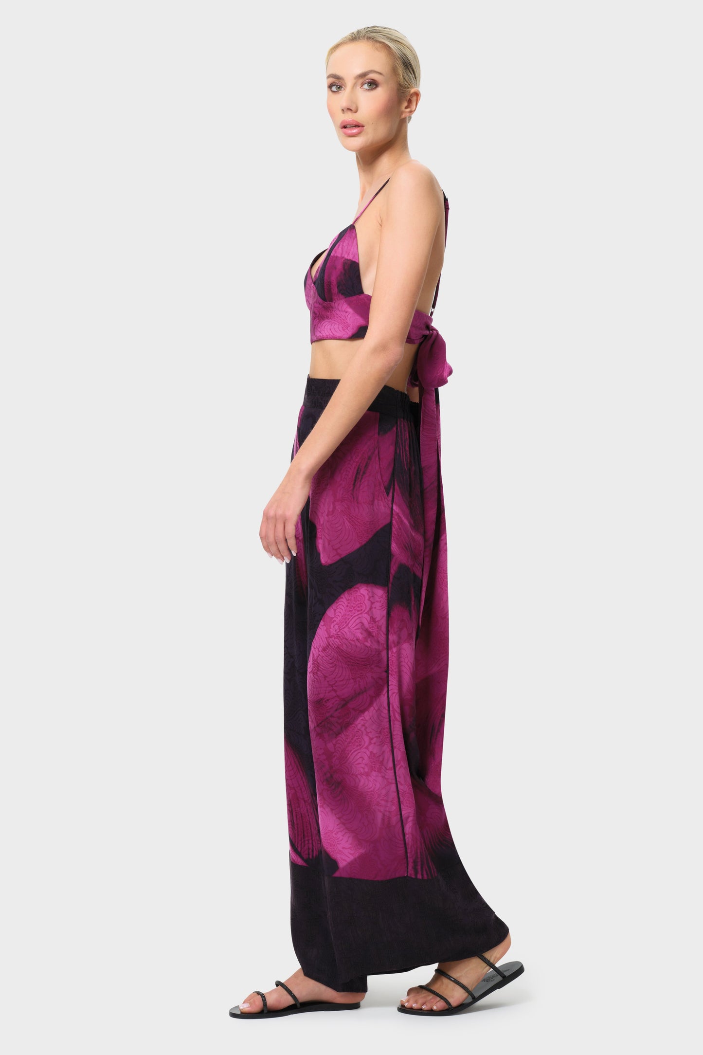 Woman wearing a pink and black patterned outfit on a white background